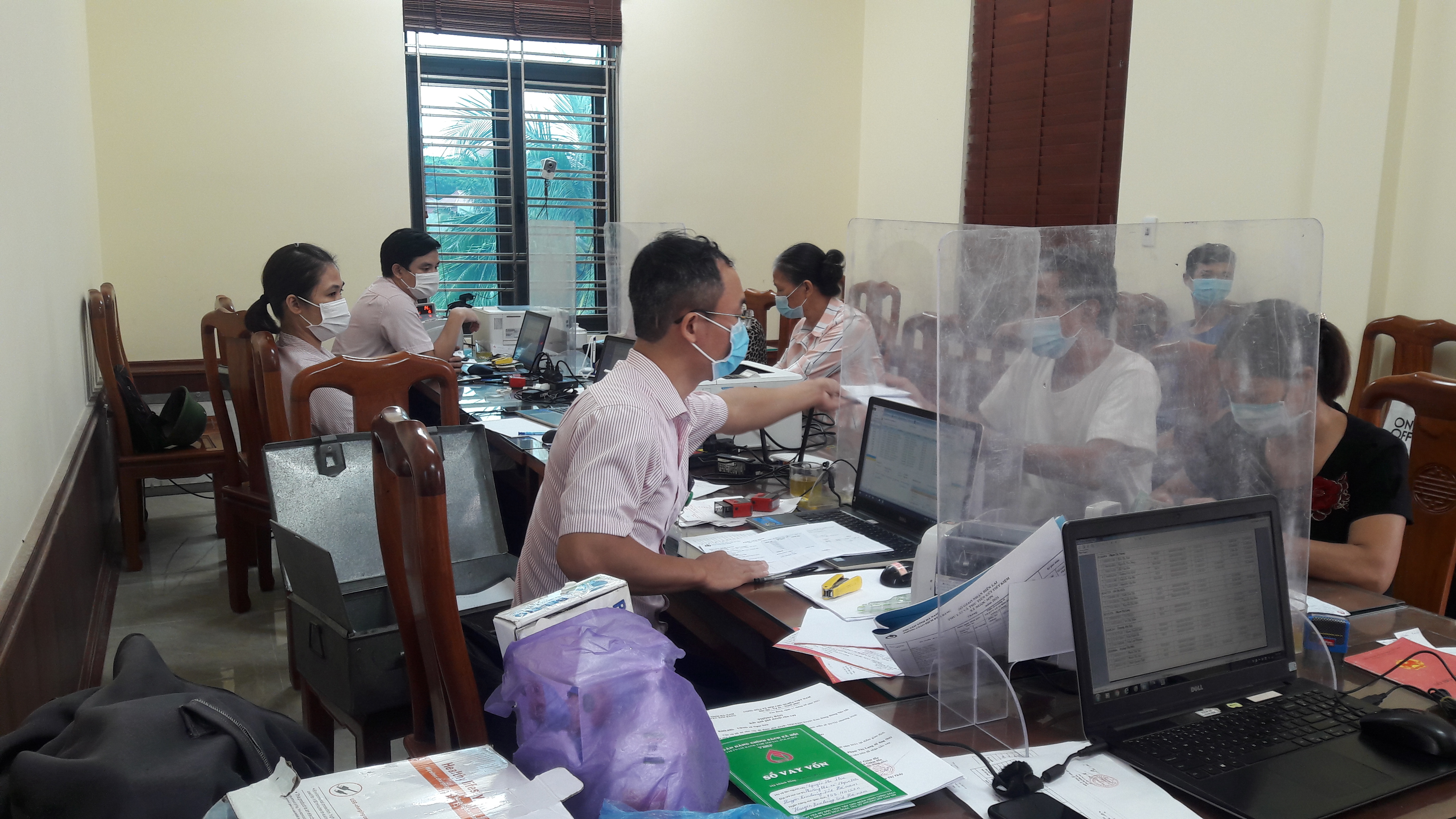 Cán bộ NHCSXH Kim Bảng thực hiện việc giải ngân vốn tại điểm giao dịch xã Ngọc Sơn.jpg